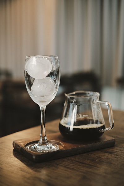 棕色木桌上的透明酒杯